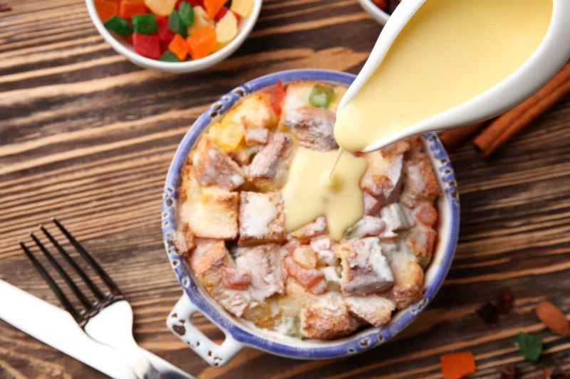 木桌上的麵包布丁和蛋奶沙司