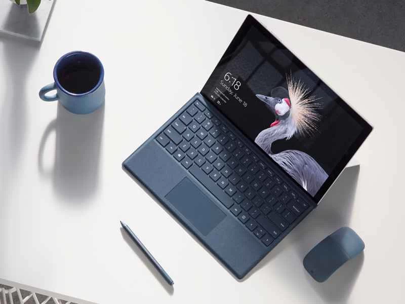 一台微軟 Surface Pro 放在白色桌上,旁邊放著一個咖啡杯。