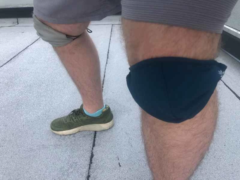 一名男子身穿短褲、運動鞋,並將布口罩當作護膝。