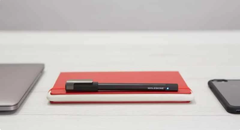 一支黑色 Moleskine 鋼筆和一本紅色平板電腦筆記本,可以用來將手寫筆記數位化。