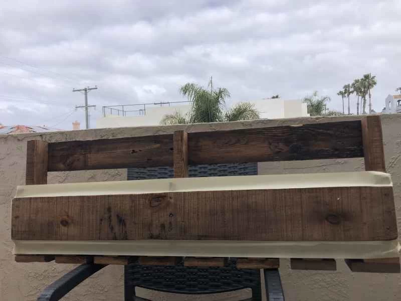 一個用木托盤製作的壁掛式酒架，正面貼有膠帶，準備安裝黑板。