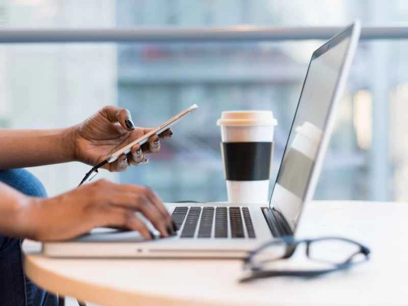 有人將手機上的資料傳輸到筆記型電腦上。