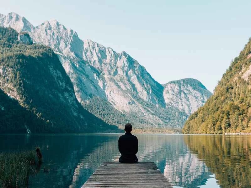 男人在碼頭上凝視著山巒。