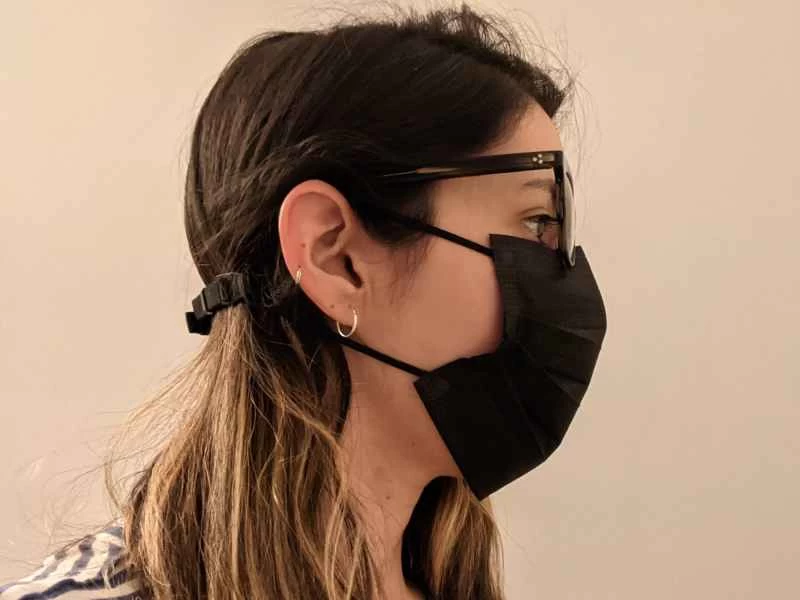 一位金髮女子戴著黑色口罩,口罩上加裝了口罩延長器,同時戴著眼鏡,以防止鏡片起霧。