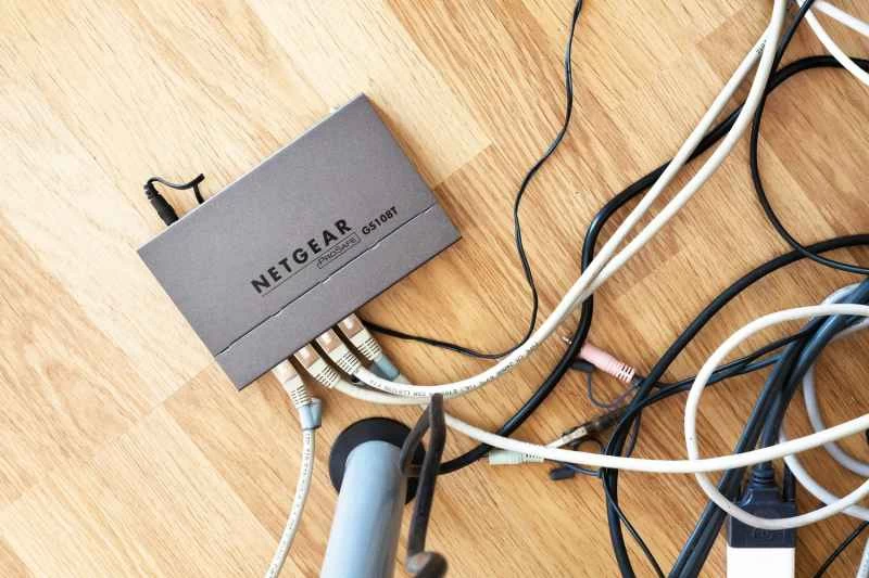 一台Netgear路由器連接很多電線，放在木地板上。