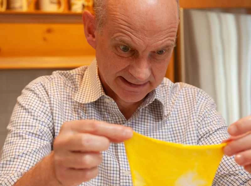 克里斯伊萊，一個男人對著一塊沾滿黃色污漬的破布做了個鬼臉。