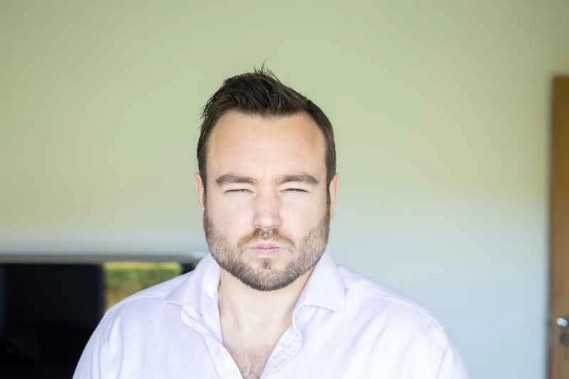 男人嘟著嘴瞇著眼睛