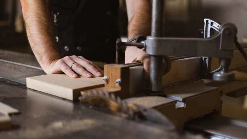 正在使用台鋸上的橫切滑台的人。