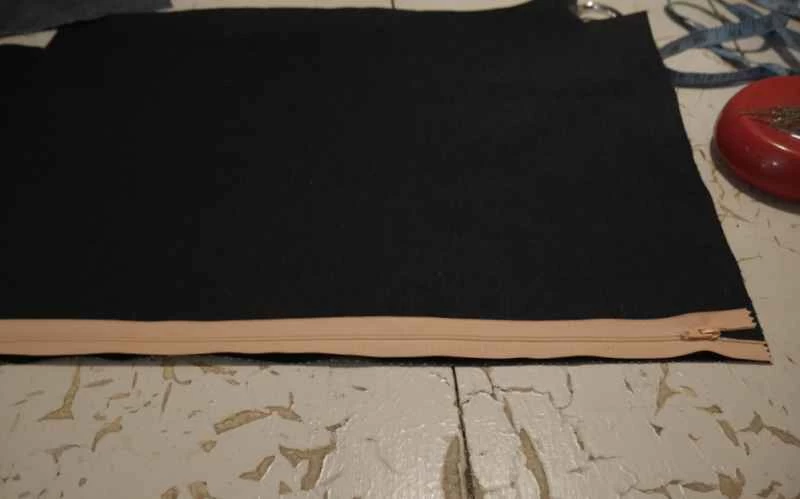 正在將拉鍊縫到用剩餘布料自製的拉鍊手提袋上